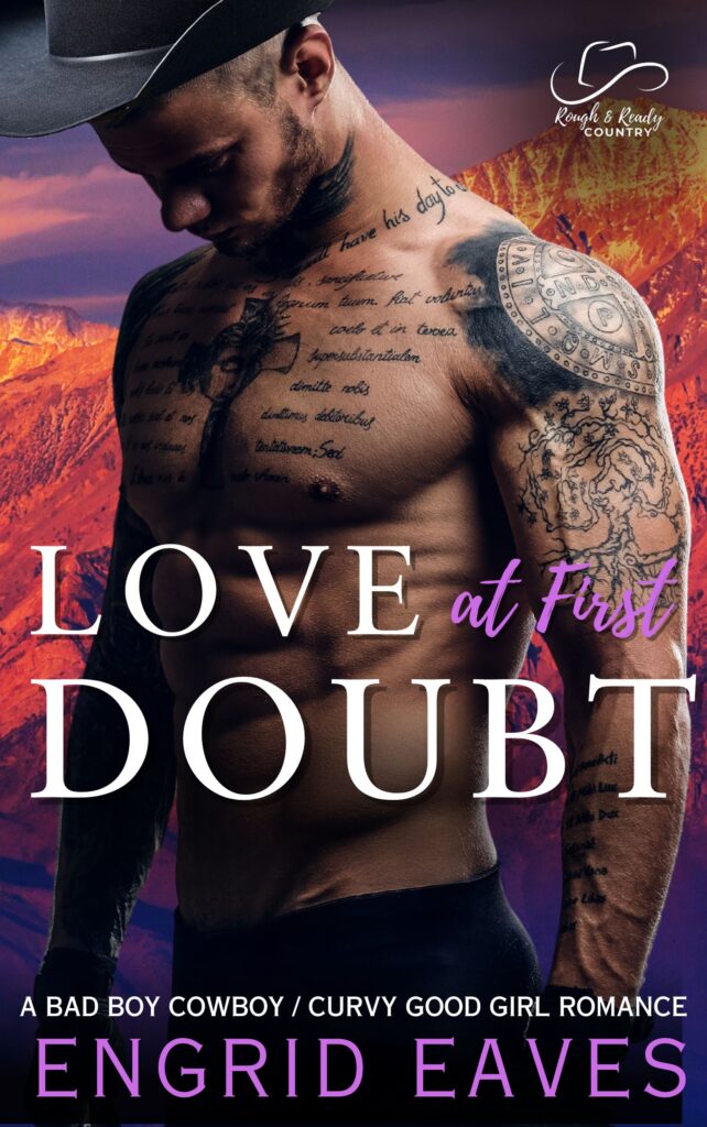 A man with tattoos and no shirt standing in front of mountains.