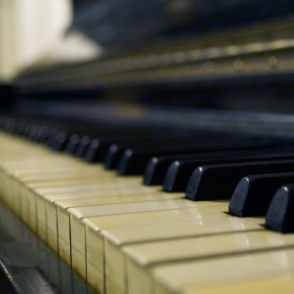 A close up of the keys on an old piano
